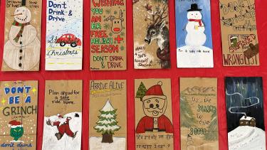 Paper bags laying flat on a red background. Bags have Christmas themed drawings on them.